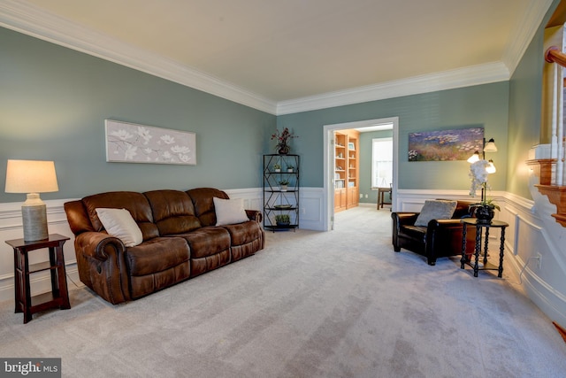 living room featuring a wainscoted wall, crown molding, and carpet floors