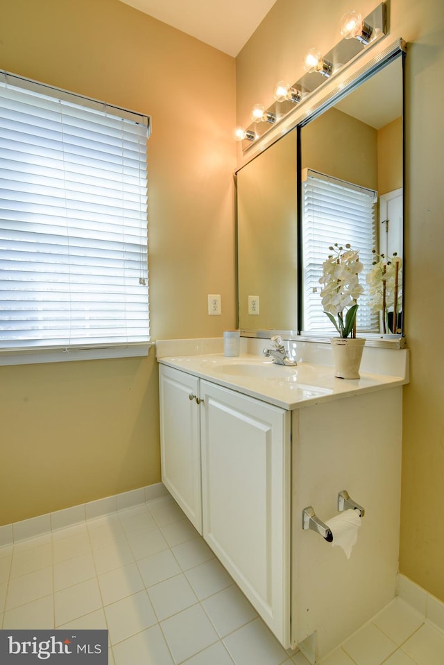 bathroom with tile patterned floors, baseboards, and vanity