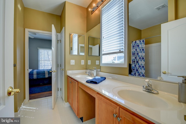 ensuite bathroom featuring double vanity, connected bathroom, visible vents, and a sink