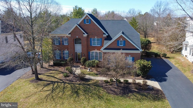 traditional home with brick siding and driveway