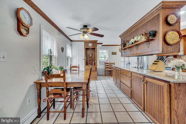 kitchen with radiator heating unit, ceiling fan, crown molding, and light tile patterned flooring