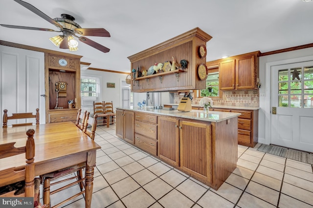 kitchen with decorative backsplash, light tile patterned floors, a healthy amount of sunlight, and ceiling fan