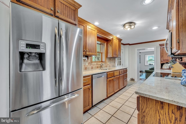 kitchen featuring decorative backsplash, appliances with stainless steel finishes, light stone counters, sink, and light tile patterned flooring