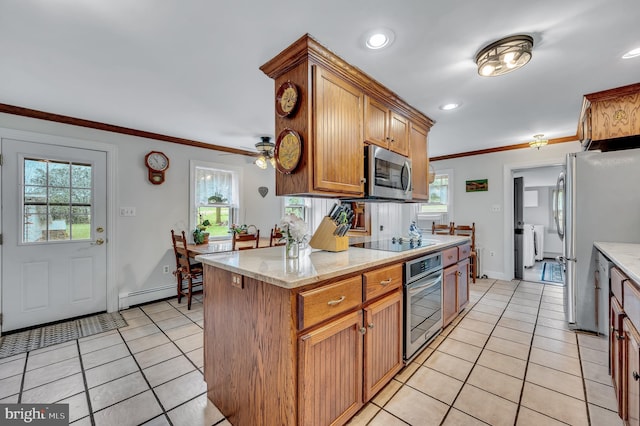 kitchen with a healthy amount of sunlight, baseboard heating, and appliances with stainless steel finishes