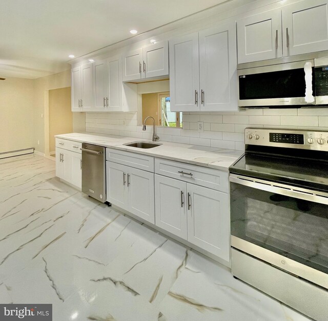 kitchen featuring light stone countertops, appliances with stainless steel finishes, tasteful backsplash, sink, and white cabinetry