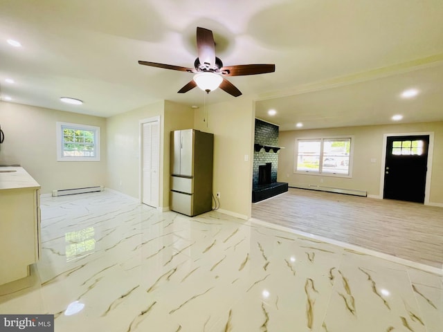 unfurnished living room with a fireplace, baseboard heating, and ceiling fan