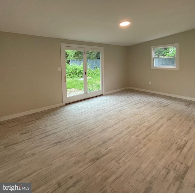 spare room featuring a wealth of natural light and light hardwood / wood-style flooring