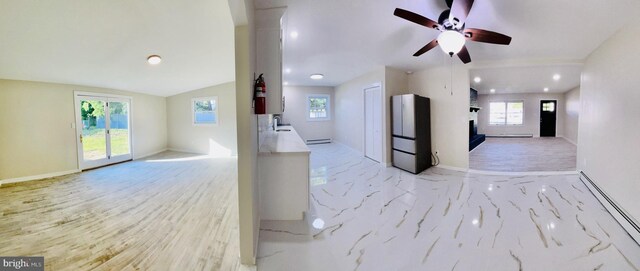 interior space with ceiling fan, baseboard heating, and vaulted ceiling