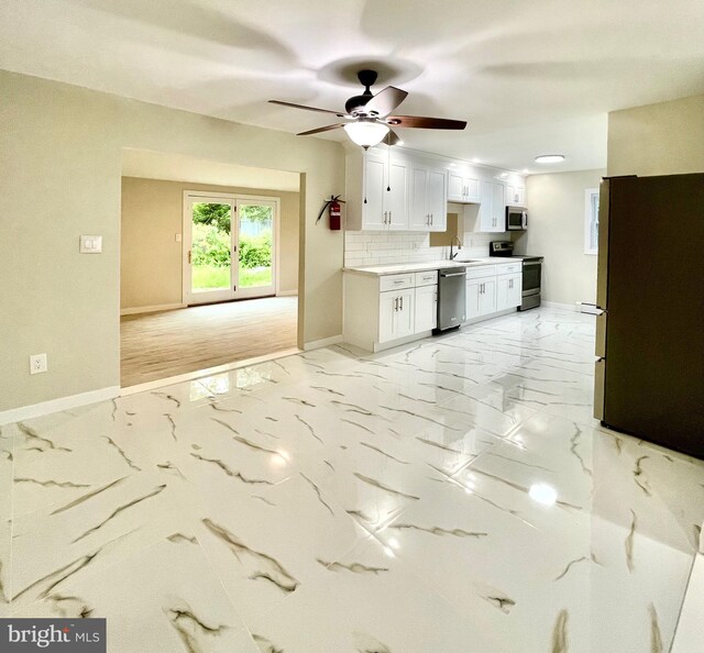 kitchen with decorative backsplash, ceiling fan, light hardwood / wood-style floors, white cabinetry, and stainless steel appliances