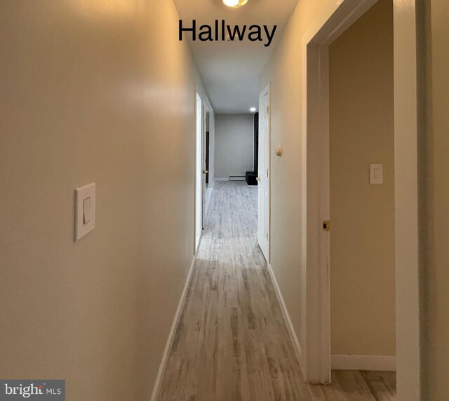 corridor featuring a baseboard radiator and light wood-type flooring