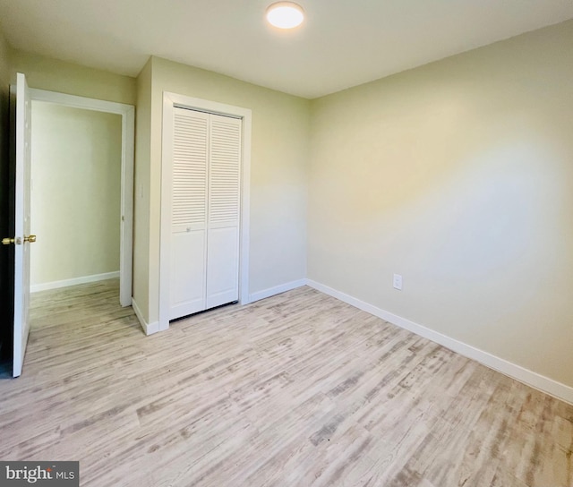 unfurnished bedroom featuring light hardwood / wood-style flooring and a closet