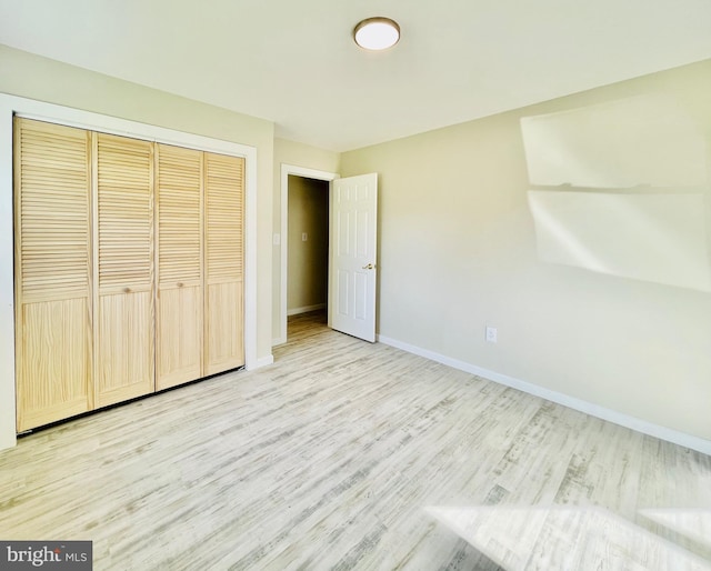 unfurnished bedroom with light hardwood / wood-style floors and a closet