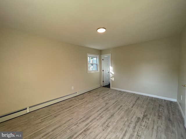 empty room featuring light wood-type flooring and baseboard heating