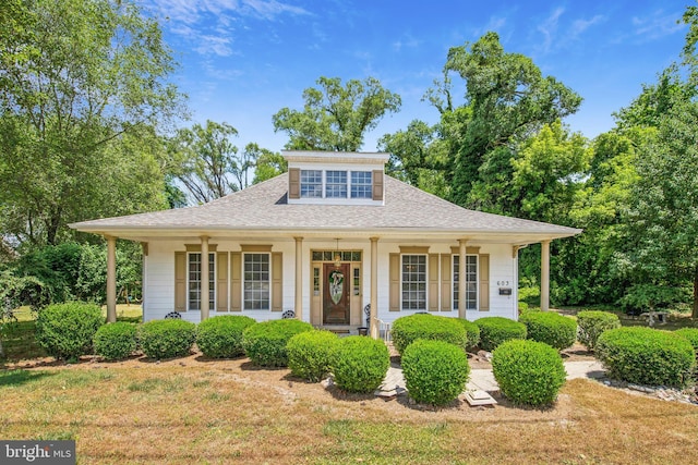 bungalow featuring covered porch and a front lawn