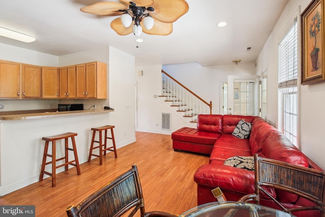 living room featuring a wealth of natural light, light hardwood / wood-style flooring, and ceiling fan