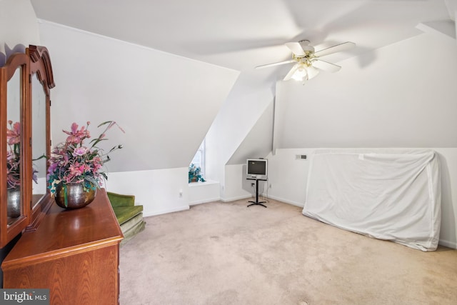 additional living space with ceiling fan, light colored carpet, and vaulted ceiling