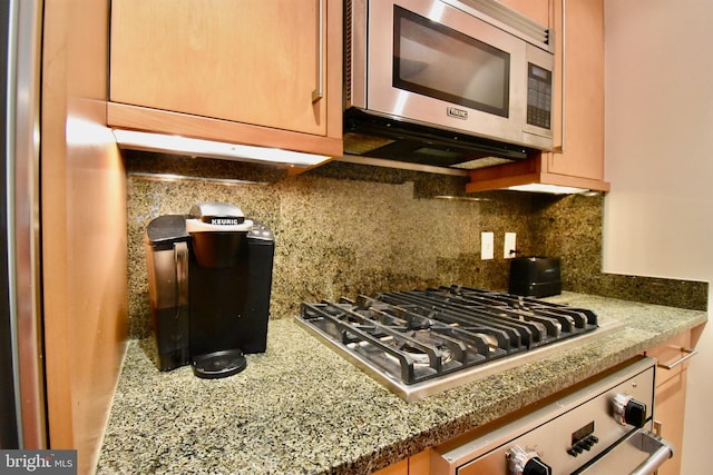 kitchen featuring decorative backsplash, stone counters, and stainless steel appliances