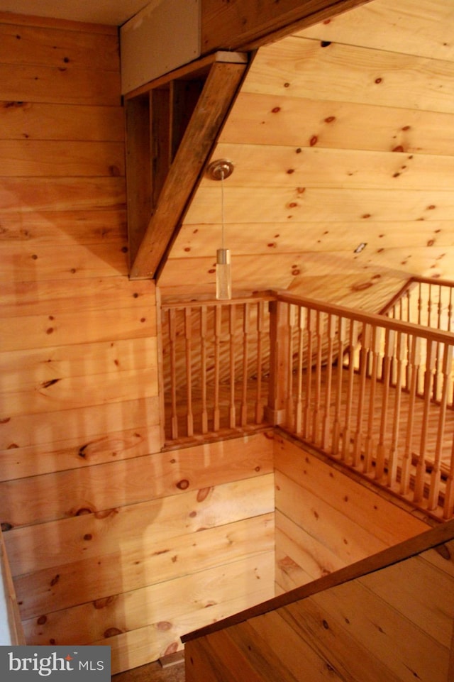 additional living space featuring wood walls and hardwood / wood-style flooring