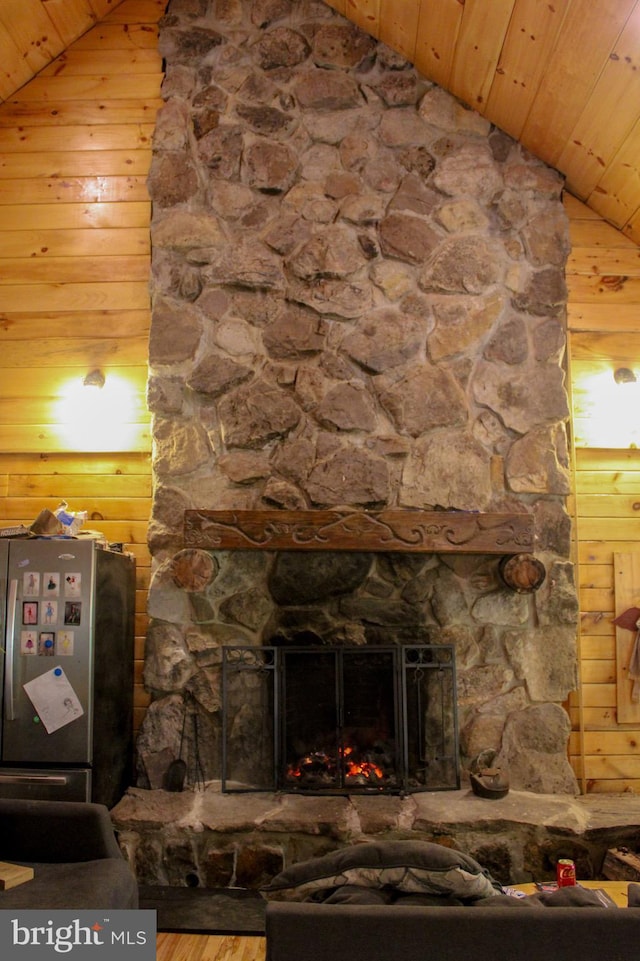 details with stainless steel refrigerator, wooden ceiling, a fireplace, and wooden walls