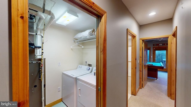 clothes washing area with washer and dryer, light carpet, and pool table