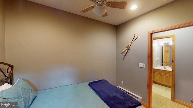 bedroom with light carpet, a baseboard heating unit, sink, ceiling fan, and connected bathroom