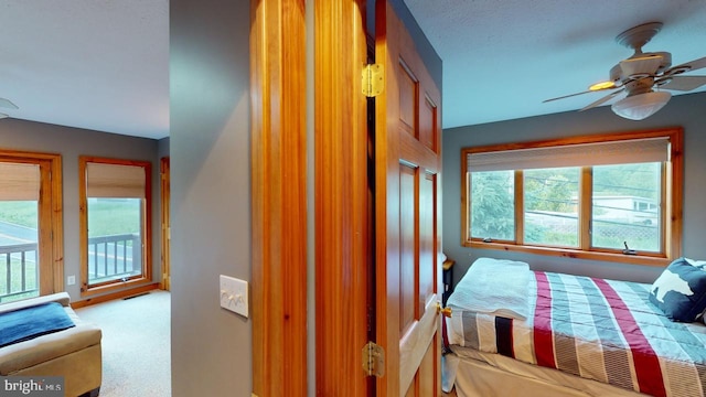 bedroom featuring access to outside, ceiling fan, and carpet