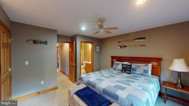 carpeted bedroom with ensuite bath and ceiling fan