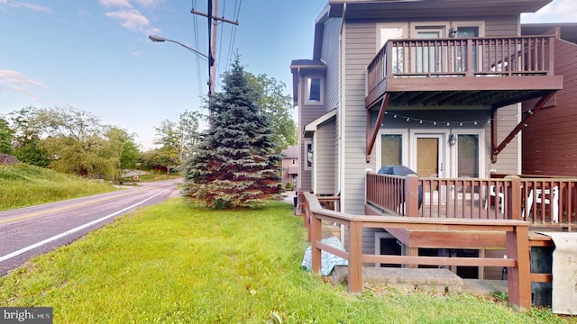 exterior space featuring a lawn and a deck