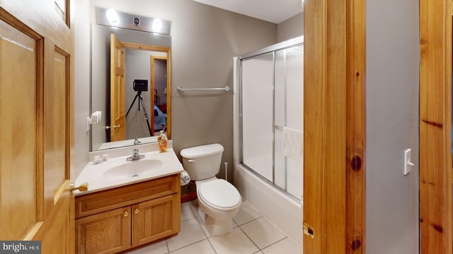 full bathroom featuring tile patterned floors, vanity, toilet, and bath / shower combo with glass door