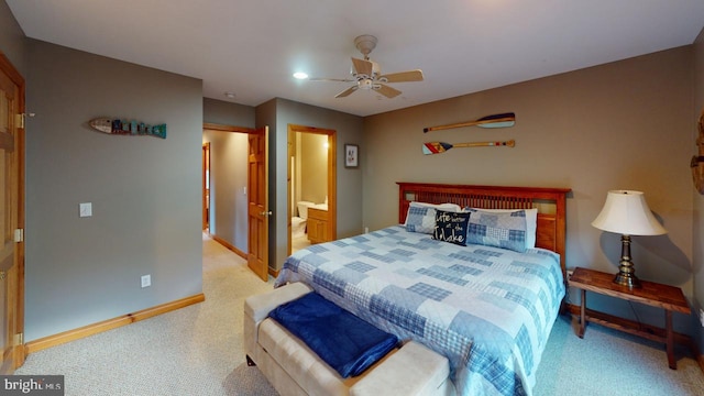 bedroom featuring ceiling fan, light colored carpet, and connected bathroom