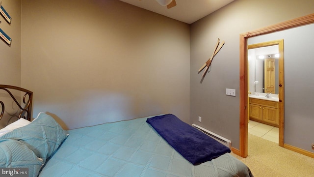 carpeted bedroom featuring connected bathroom, baseboard heating, and sink