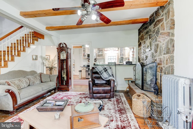 living room featuring beam ceiling, radiator, ceiling fan, and a fireplace