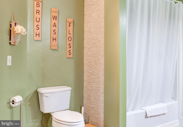 bathroom featuring toilet and shower / tub combo with curtain