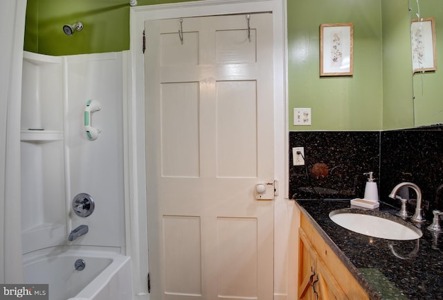 bathroom featuring vanity, washtub / shower combination, and backsplash