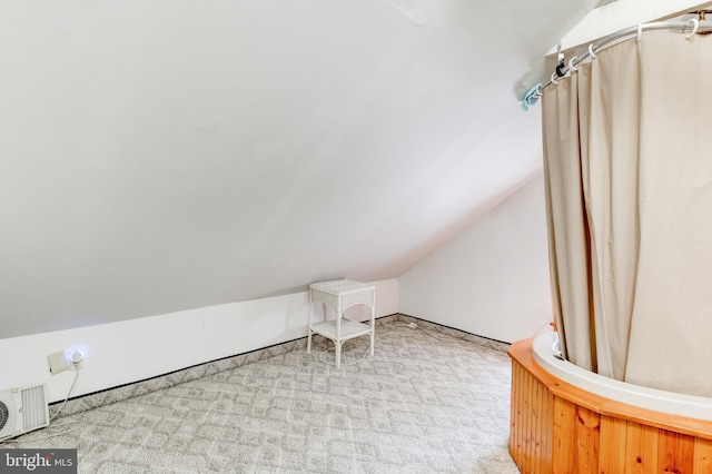 bonus room featuring light carpet and vaulted ceiling