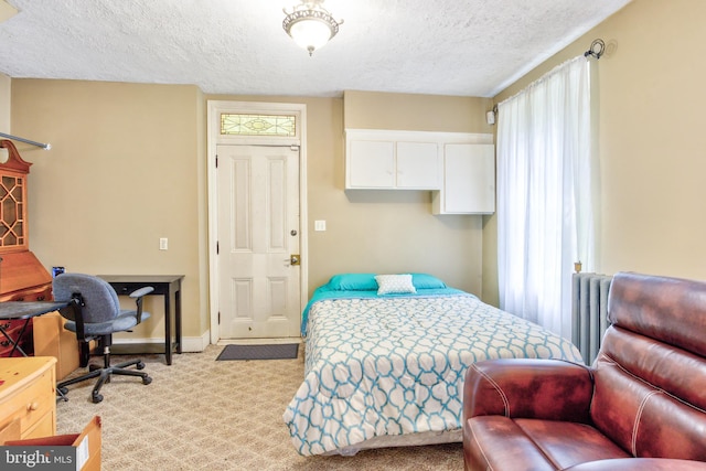 bedroom with multiple windows, light carpet, and a textured ceiling