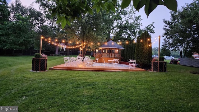 yard at dusk featuring a wooden deck