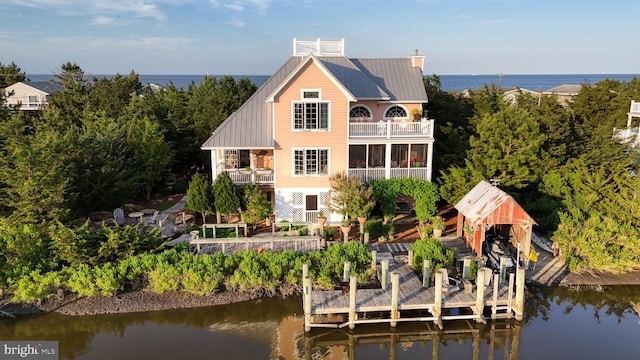 rear view of property with a balcony and a water view