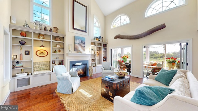 interior space with a wealth of natural light, high vaulted ceiling, and hardwood / wood-style flooring