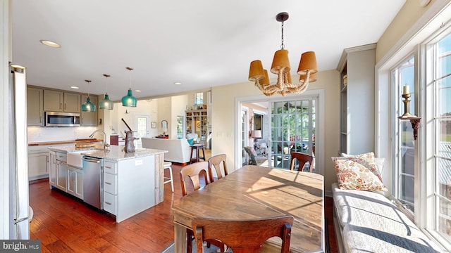 dining area featuring sink, dark hardwood / wood-style floors, and a notable chandelier