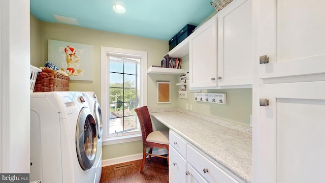 laundry area featuring dark hardwood / wood-style floors, cabinets, and washing machine and dryer