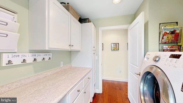 laundry room with cabinets, washer / dryer, and hardwood / wood-style flooring