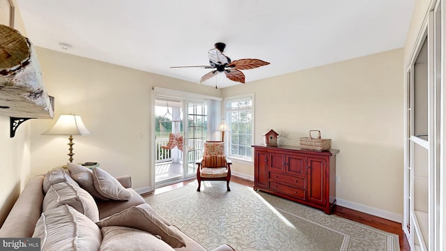 living room featuring ceiling fan and hardwood / wood-style flooring