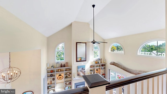 interior space with ceiling fan with notable chandelier and vaulted ceiling