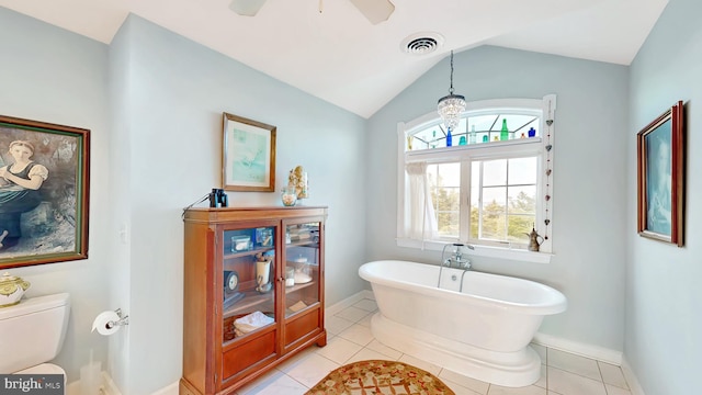 bathroom with a tub to relax in, tile patterned floors, vaulted ceiling, ceiling fan, and toilet