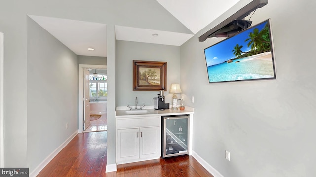 bar featuring sink, white cabinetry, dark wood-type flooring, and beverage cooler