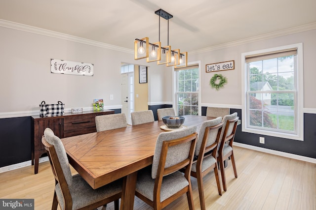 dining room featuring light hardwood / wood-style floors, ornamental molding, and an inviting chandelier