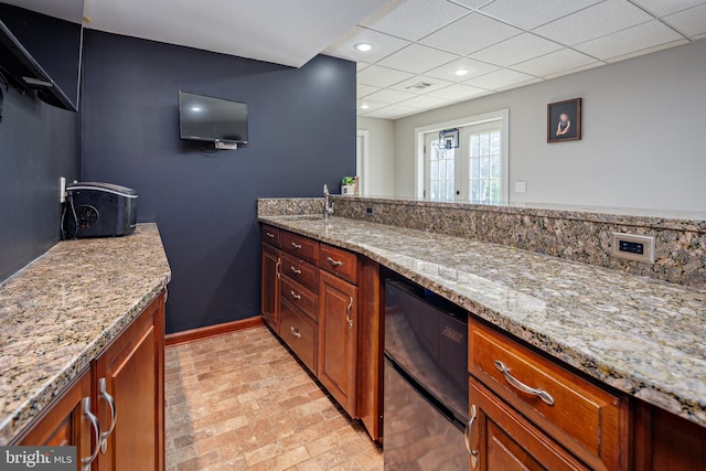 kitchen with light stone counters, sink, and french doors