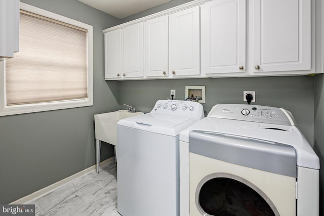 laundry area with washing machine and clothes dryer and cabinets