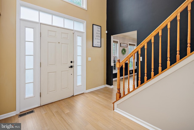 foyer entrance featuring light hardwood / wood-style floors and ornamental molding